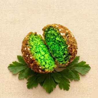 Aufgebrochene Green Gold Falafel — leuchtend grünes Inneres